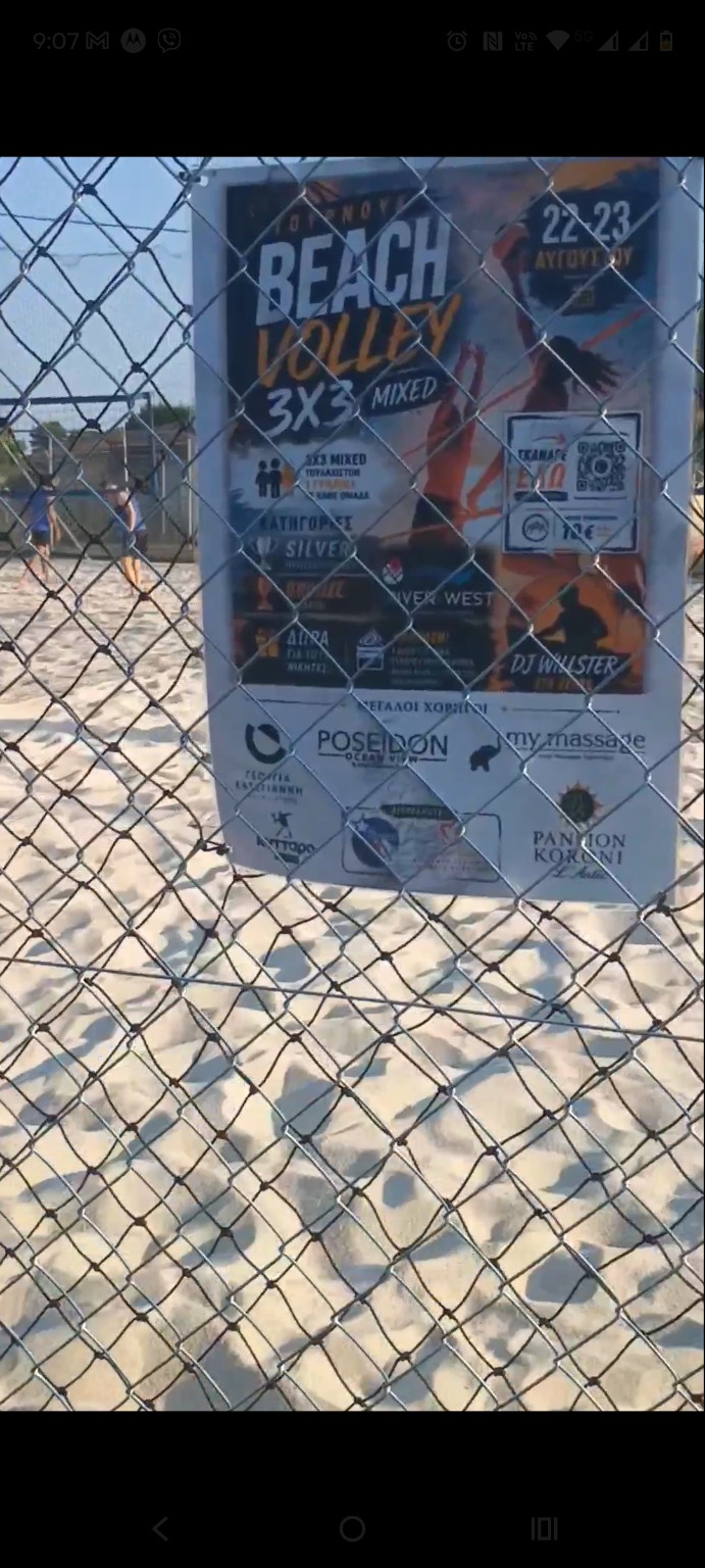 Tournament poster beside the beach volleyball court