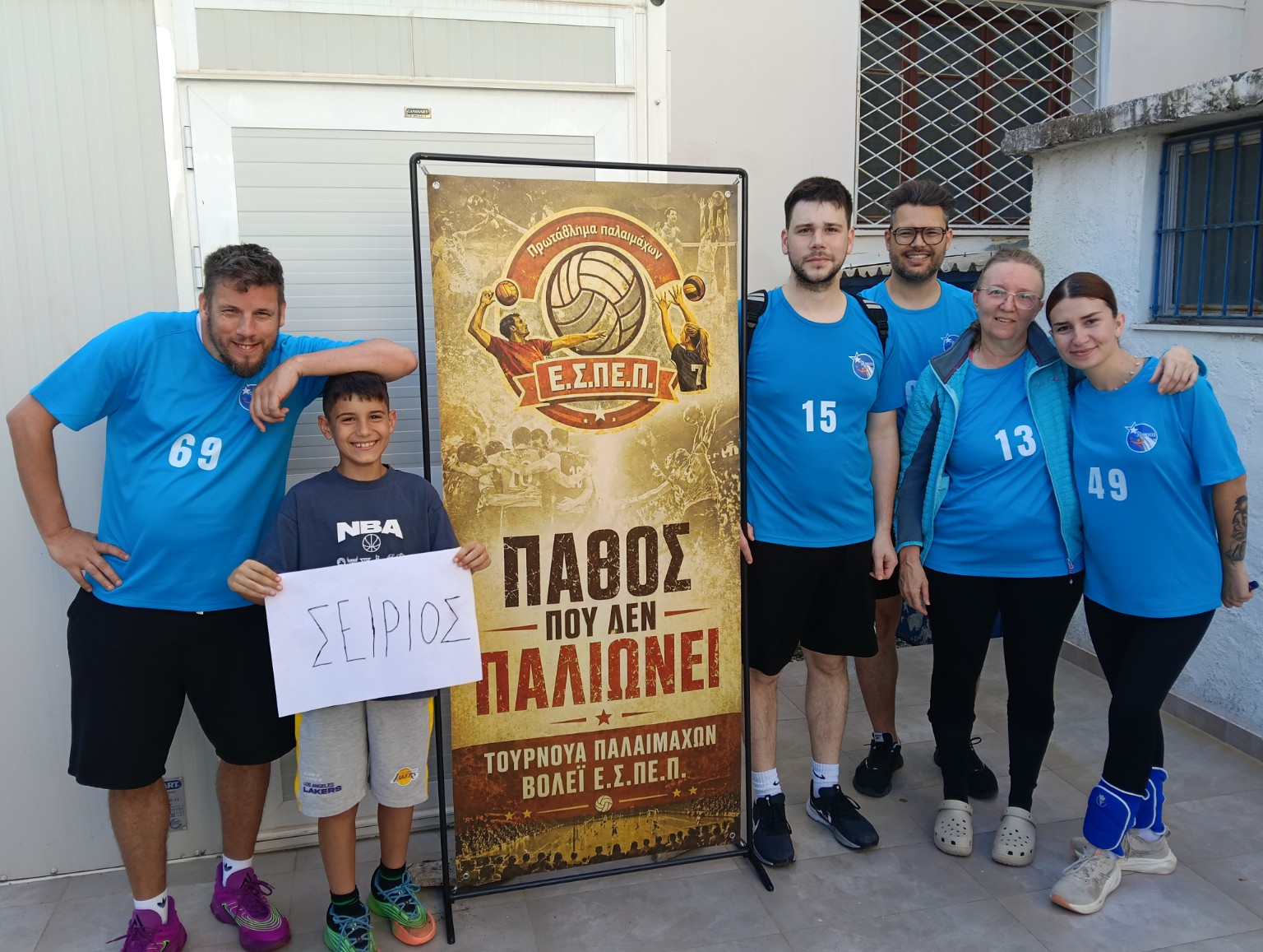 The G.E. SEIRIOS team beside the tournament poster